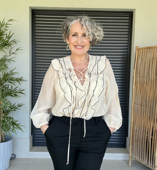 Blusa de Gasa Beige con Ribetes Negros, Volantes y Cordón Cruzado